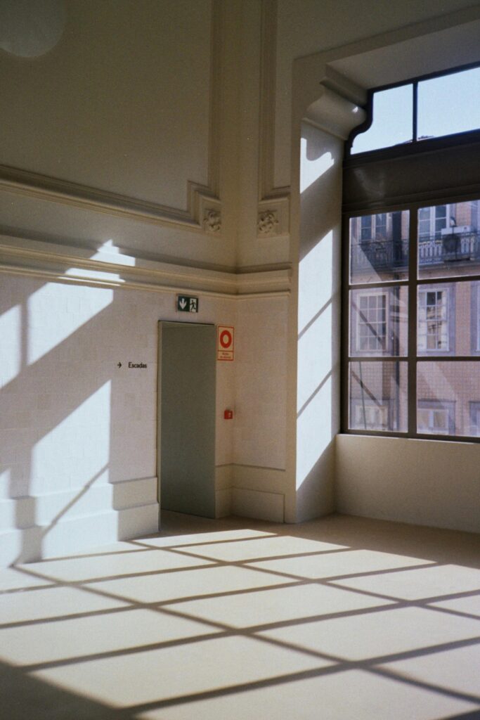 Sunlit room with architectural details and shadows, Porto, Portugal.